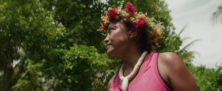 A woman in a flower crown looks up