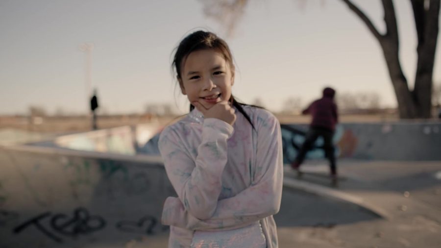 A girl smiles at a skate park