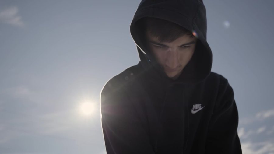 A young man in a hoodie, backlit by the sun